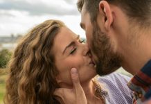 Swipe Safer: How to Spot and Avoid Hookup App Scams Close-up of a couple sharing a passionate kiss outdoors, capturing a moment of romance and affection.
