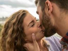 Swipe Safer: How to Spot and Avoid Hookup App Scams Close-up of a couple sharing a passionate kiss outdoors, capturing a moment of romance and affection.
