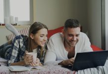 How to Master Search Filters on Adult Tube Sites Couple looking at a laptop on a bed