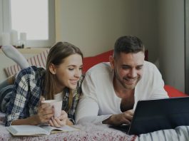 How to Master Search Filters on Adult Tube Sites Couple looking at a laptop on a bed