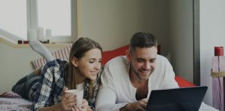 How to Master Search Filters on Adult Tube Sites Couple looking at a laptop on a bed