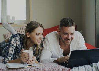 How to Master Search Filters on Adult Tube Sites Couple looking at a laptop on a bed