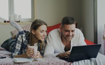 How to Master Search Filters on Adult Tube Sites Couple looking at a laptop on a bed